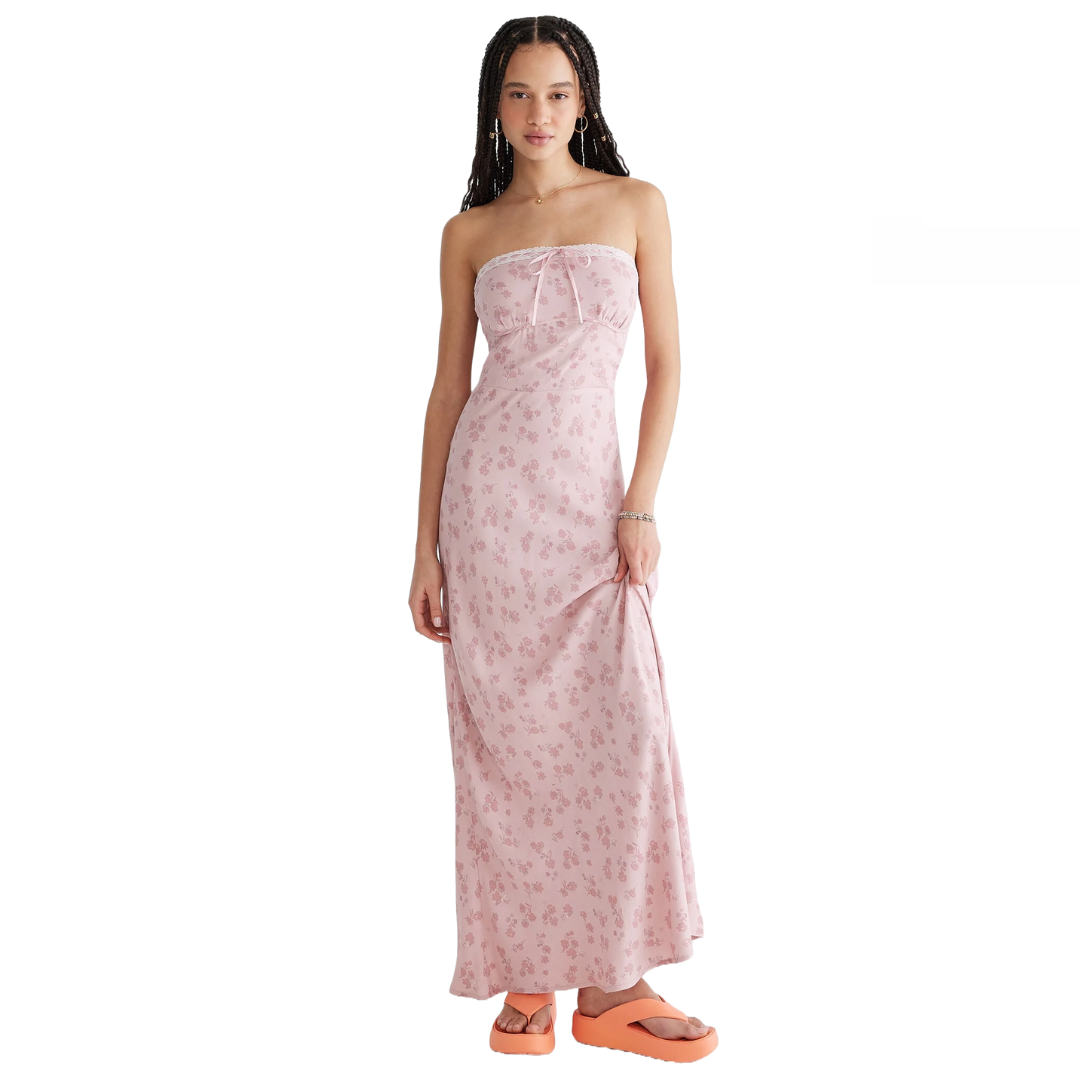 A woman is wearing a strapless pink floral maxi dress paired with chunky orange platform sandals.