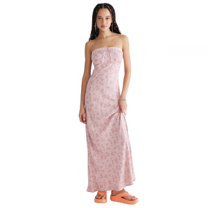 A woman is wearing a strapless pink floral maxi dress paired with chunky orange platform sandals.
