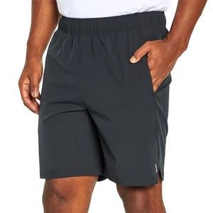A person is wearing black athletic shorts with an elastic waistband and side pockets.
