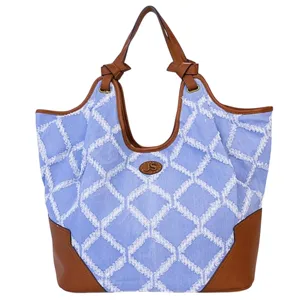 A blue and tan tote bag with a white diamond pattern, leather accents, and leather handles.