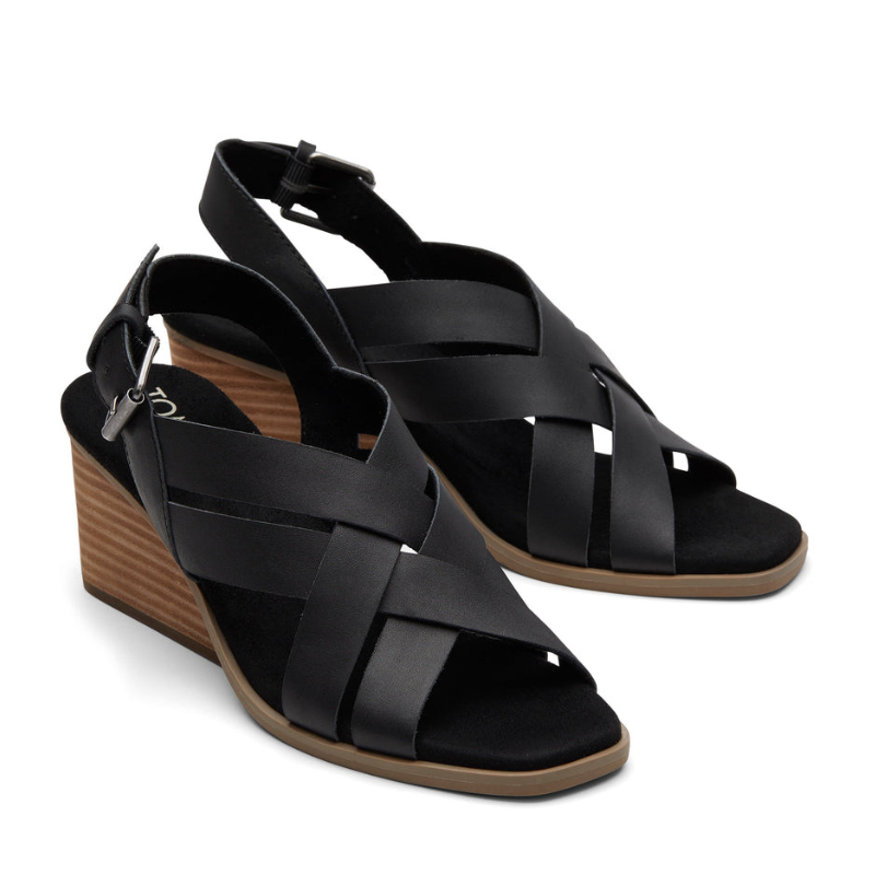 Black wedge sandals with crisscross straps and a buckle closure, featuring a wooden heel for added style.