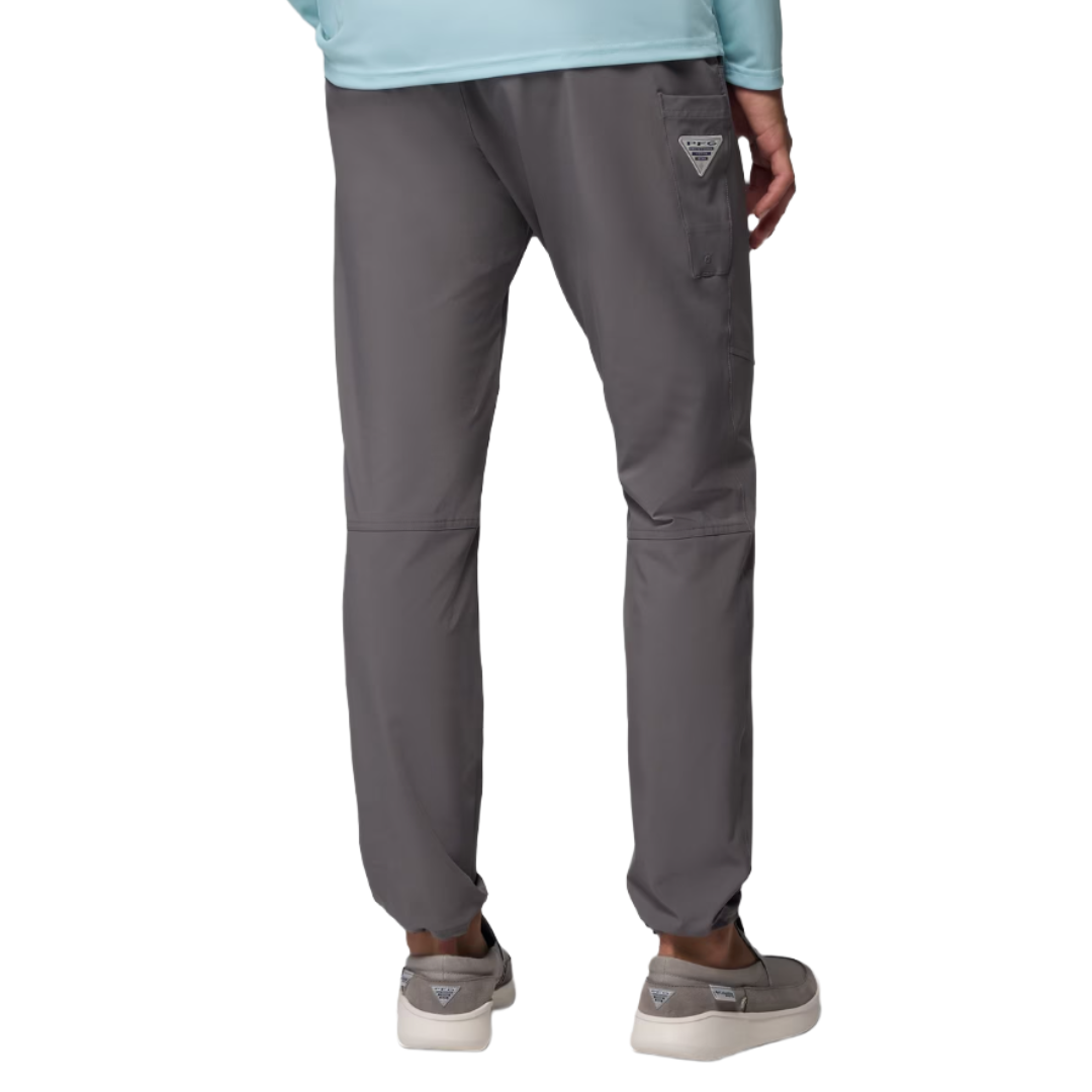 Gray pants with a relaxed fit, featuring a side pocket with a small triangular logo. Paired with gray slip-on shoes and a light blue top.