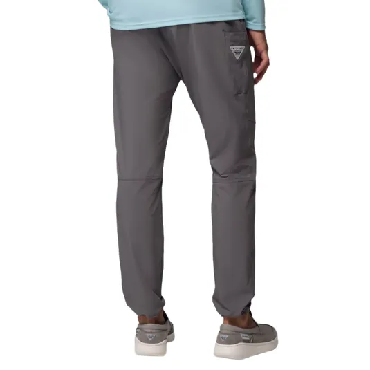 Gray pants with a relaxed fit, featuring a side pocket with a small triangular logo. Paired with gray slip-on shoes and a light blue top.