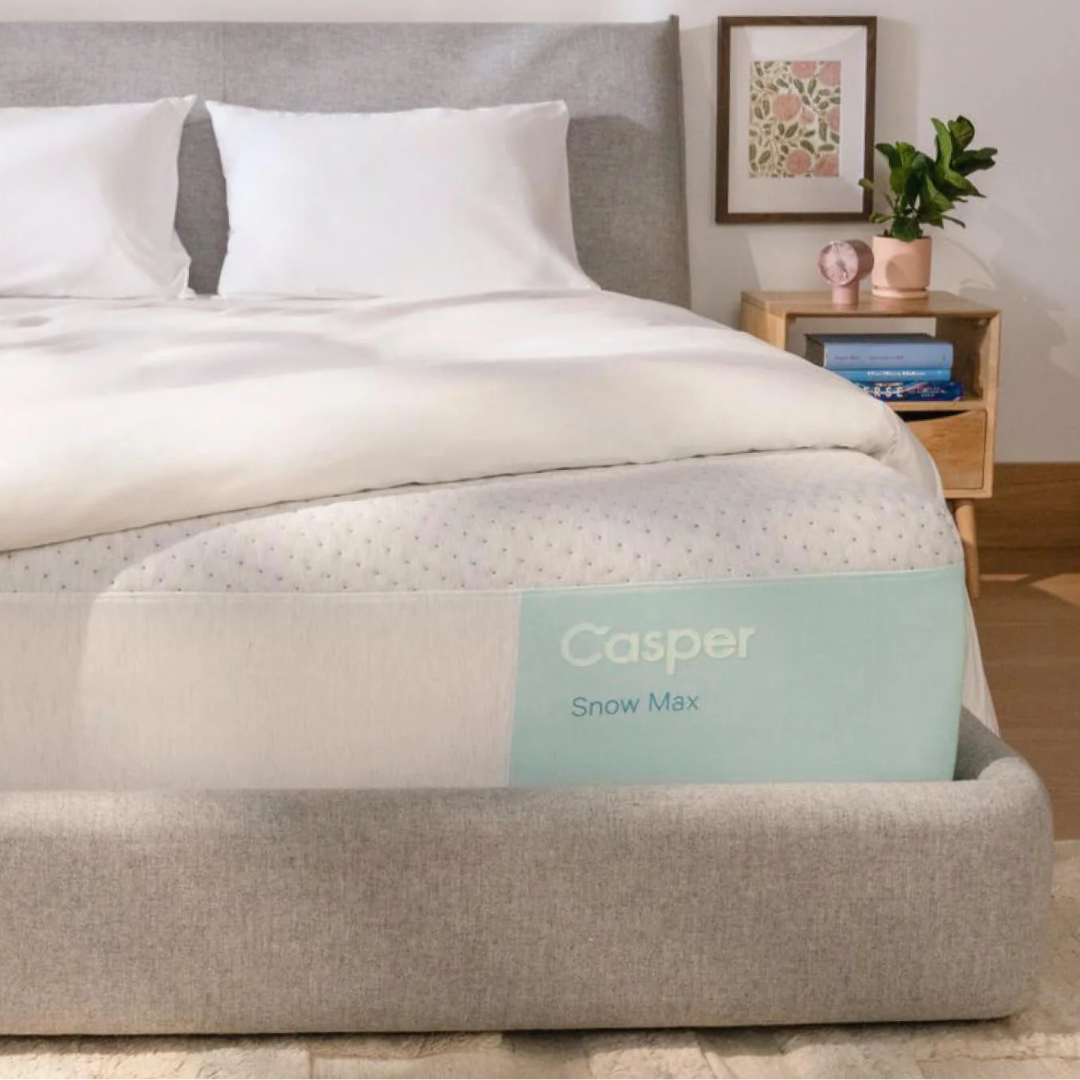 Casper Snow Max Cooling Mattress features cooling technology, a light gray and white design, and is presented on a modern upholstered bed frame.