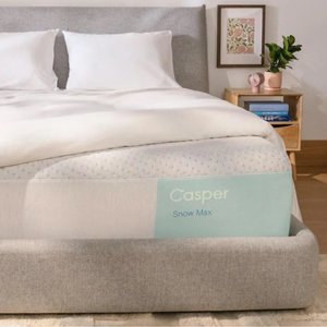 Casper Snow Max Cooling Mattress features cooling technology, a light gray and white design, and is presented on a modern upholstered bed frame.
