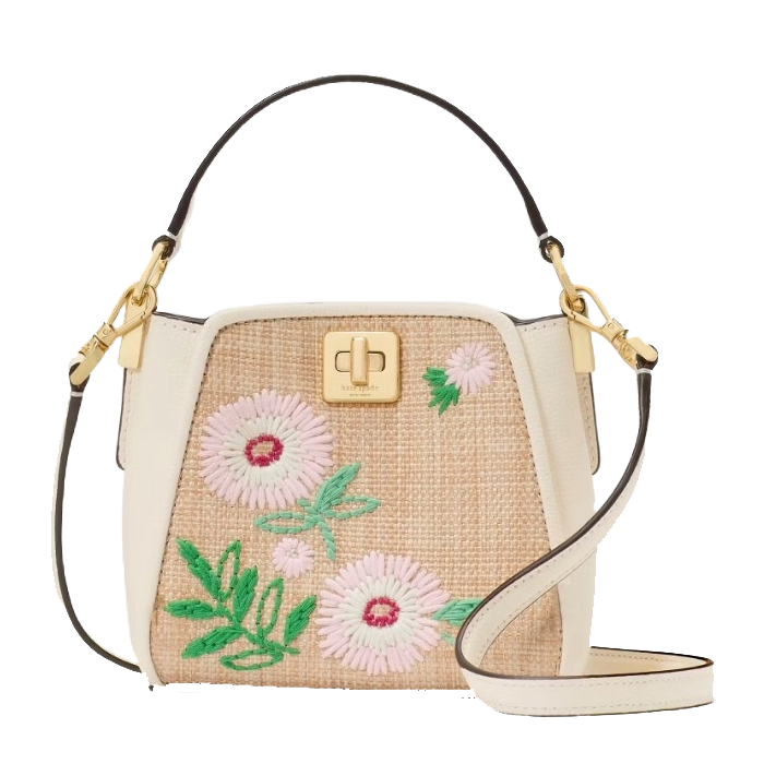 A stylish handbag with floral embroidery on a woven base, featuring a white leather trim, gold-tone hardware, and adjustable shoulder strap.