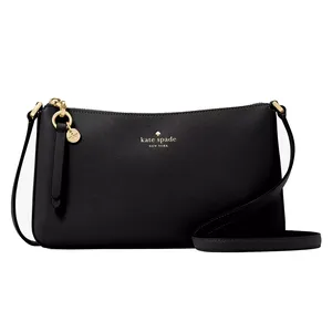Kate Spade Ginnie Crossbody is a sleek black bag with a minimalist design, featuring gold-tone hardware, a zip closure, and a long adjustable strap. A small gold logo and charm details accentuate its elegant appearance.
