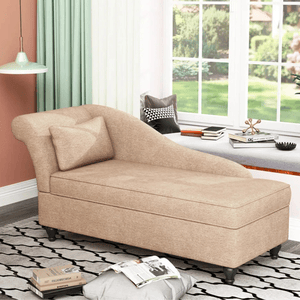 A beige upholstered chaise lounge with a pillow is set in a room with a window seat, books, a decorative sculpture, and a pendant light, against a background of peach walls and green curtains.