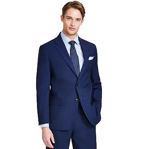 A man is wearing a dark blue suit with a white dress shirt and a blue tie featuring polka dots.