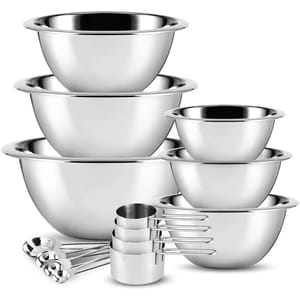 A 14-piece stainless steel nested mixing bowl set including bowls of various sizes, measuring cups, and measuring spoons. The set is designed for efficient storage and versatile kitchen use.