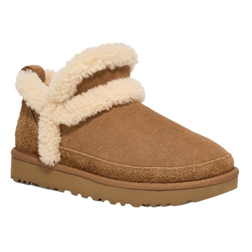 A tan suede ankle boot with a fluffy cream shearling trim and a flat sole.