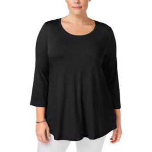 A woman models a black three-quarter sleeve tunic top paired with white pants. The tunic has a scoop neckline and a relaxed fit.