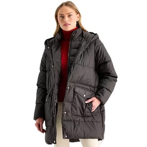 A woman is wearing a black puffer jacket with a hood over a red turtleneck sweater.