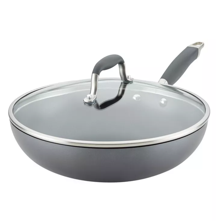 A deep skillet with a glass lid and a rubberized handle, featuring a sleek gray finish and metal rim.
