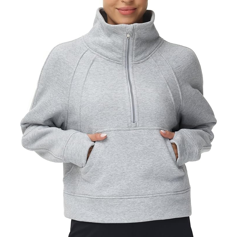 A person wears a gray, long-sleeve, half-zip pullover sweatshirt with a high collar and a kangaroo pocket.
