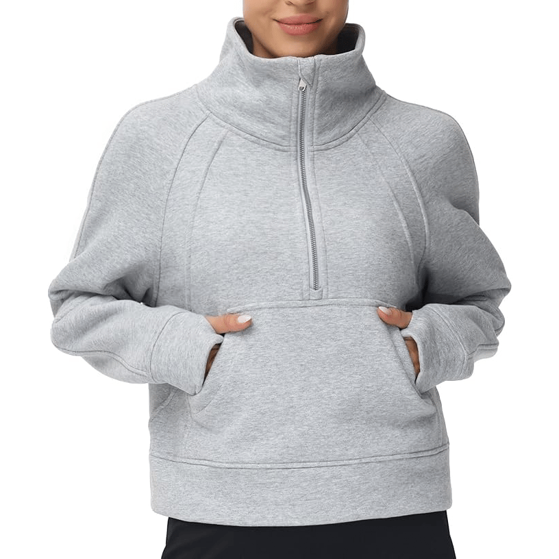 A person wears a gray, long-sleeve, half-zip pullover sweatshirt with a high collar and a kangaroo pocket.
