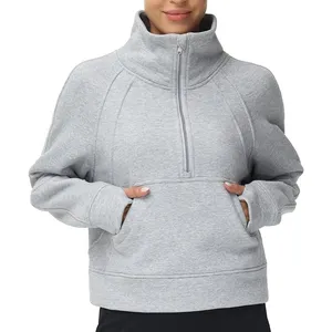 A person wears a gray, long-sleeve, half-zip pullover sweatshirt with a high collar and a kangaroo pocket.