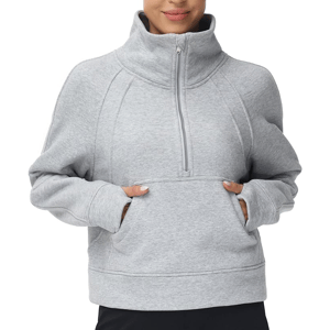 A person wears a gray, long-sleeve, half-zip pullover sweatshirt with a high collar and a kangaroo pocket.
