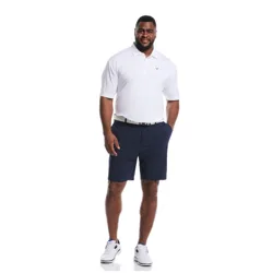 A man is wearing a white polo shirt, navy shorts, a black belt, and white sneakers.