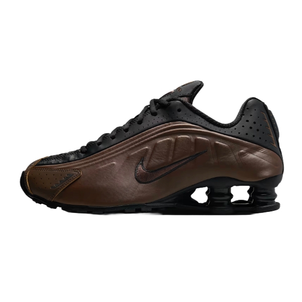 A black and brown athletic shoe featuring the Nike logo and a distinctive Shox cushioning system in the sole.