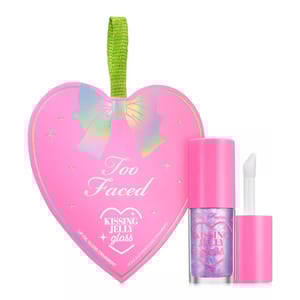 Too Faced Kissing Jelly Gloss Lip Oil Ornament in a heart-shaped pink package with iridescent bow design. Includes a matching pink applicator.