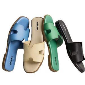 Four pairs of Sonoma slide sandals in blue, beige, green, and black with a simple design featuring an open toe and a band with cutout detail.