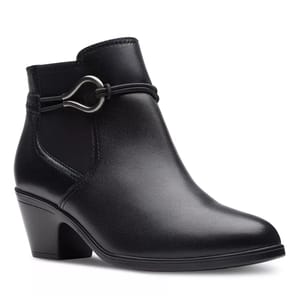 The Clarks Emily 2 Kaylie Dress Booties are sleek black ankle boots with a mid-height block heel and decorative strap detail featuring a silver metal loop. The boots have a smooth leather finish, offering a stylish and versatile look.