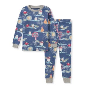 Burt's Bees Organic Cotton Pajamas feature a festive winter-themed print with various animals and a \“Santa's Workshop\“ sign on a blue background. The set includes a long-sleeve top and matching pants with grey cuffs.