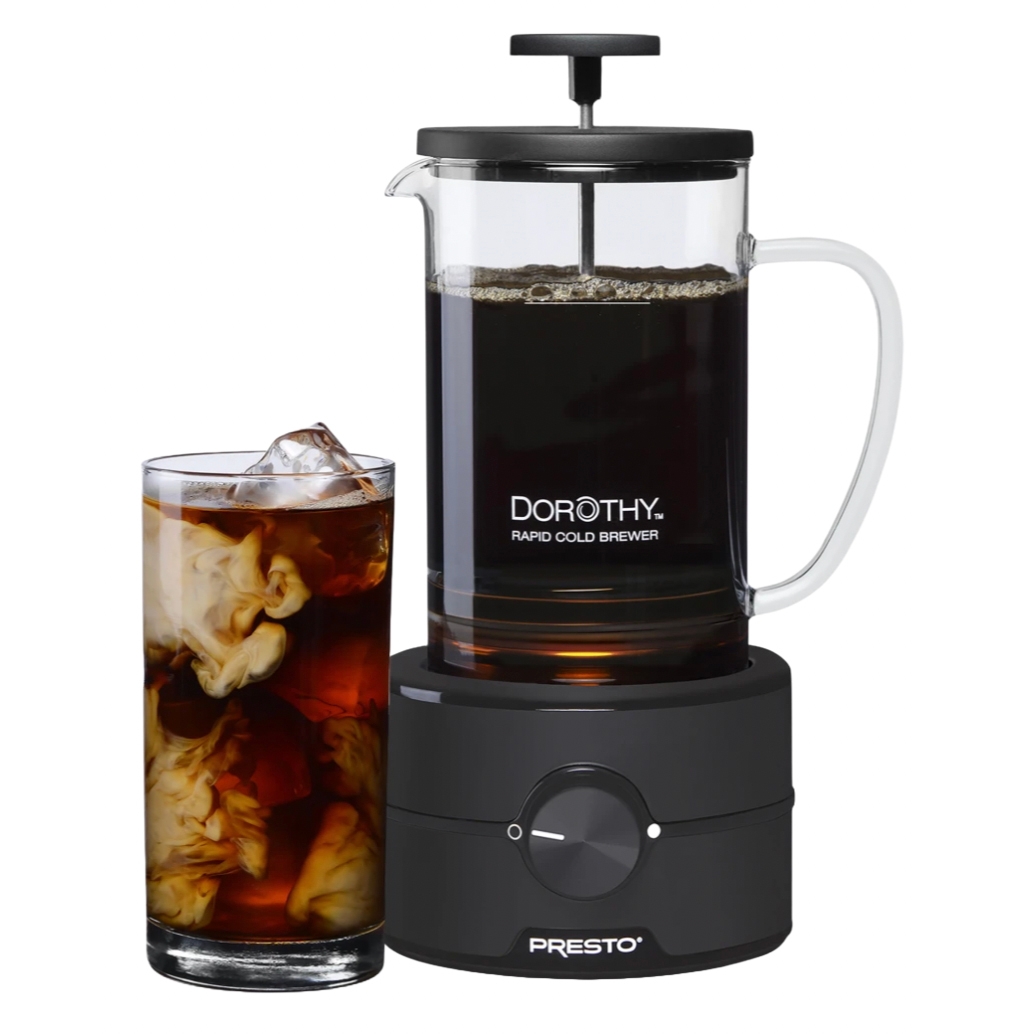 22oz Dorothy Rapid Cold Brewer by Presto, featuring a glass brewing container with a plunger and handle, sits on an electric base. Accompanied by a glass of cold brew coffee with cream swirling inside.