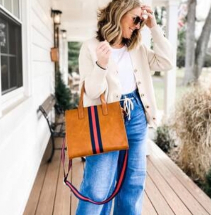 Tan tote bag with blue and red vertical stripes, featuring a spacious main compartment and long shoulder straps.
