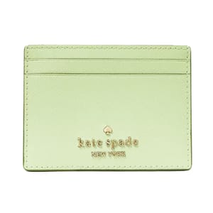 A light green Kate Spade cardholder featuring gold embossed branding and two card slots on the front.
