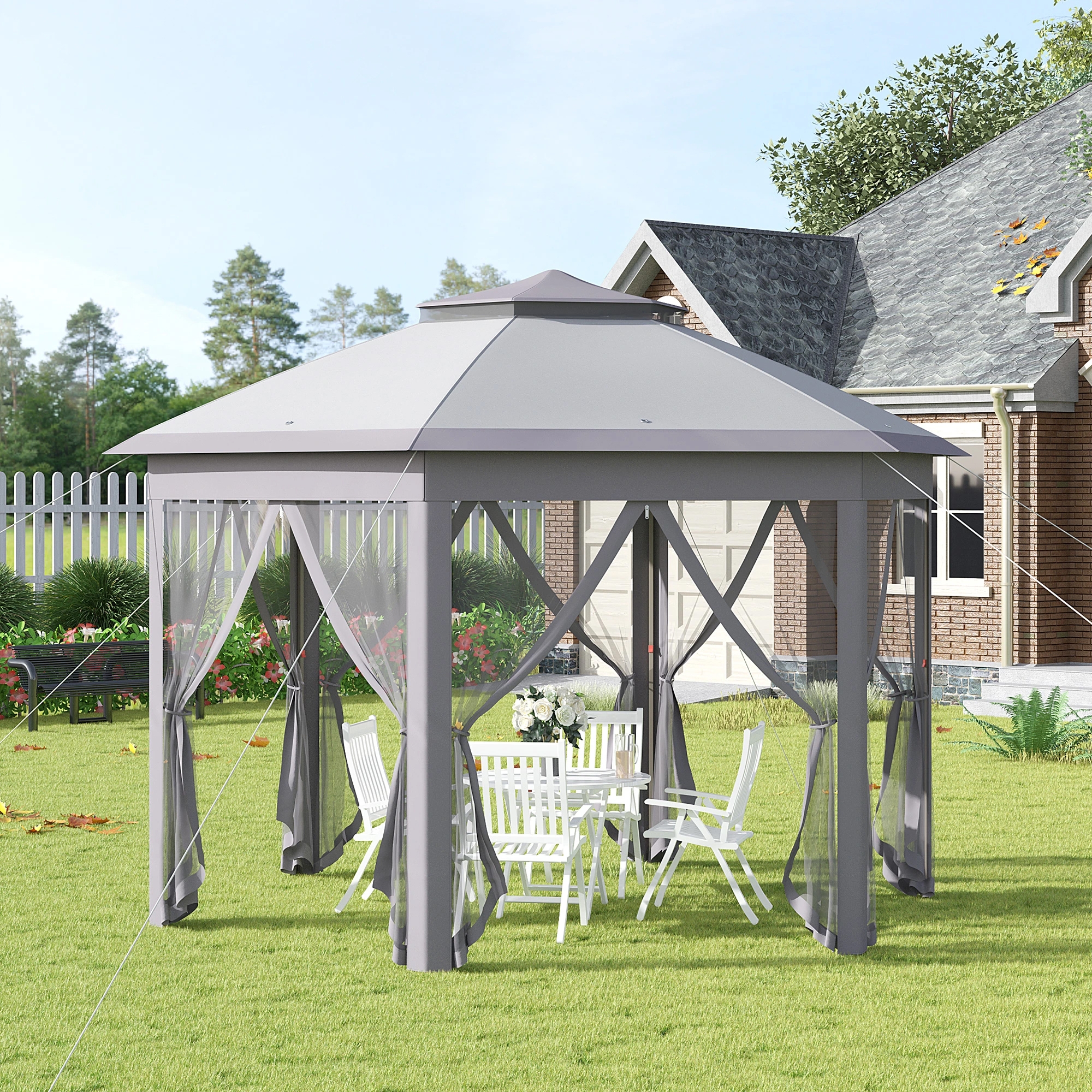 A 13-foot canopy gazebo tent with a gray, durable fabric roof, netted curtains, and sturdy metal frame, featuring a round table with white chairs underneath, set on a grassy lawn beside a brick house with surrounding greenery and a picket fence.