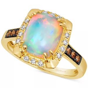 Gold ring featuring a cushion-cut opal centerpiece, surrounded by small diamonds. The band includes additional brown diamonds set in a black accent.