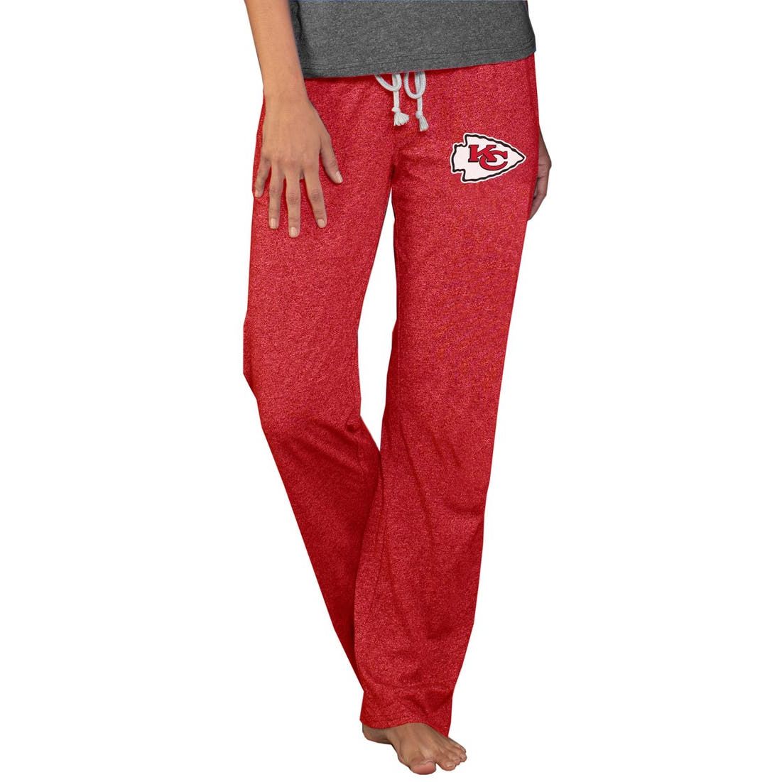 Red lounge pants featuring the Kansas City Chiefs logo on the thigh, with a drawstring waist, paired with a gray shirt.