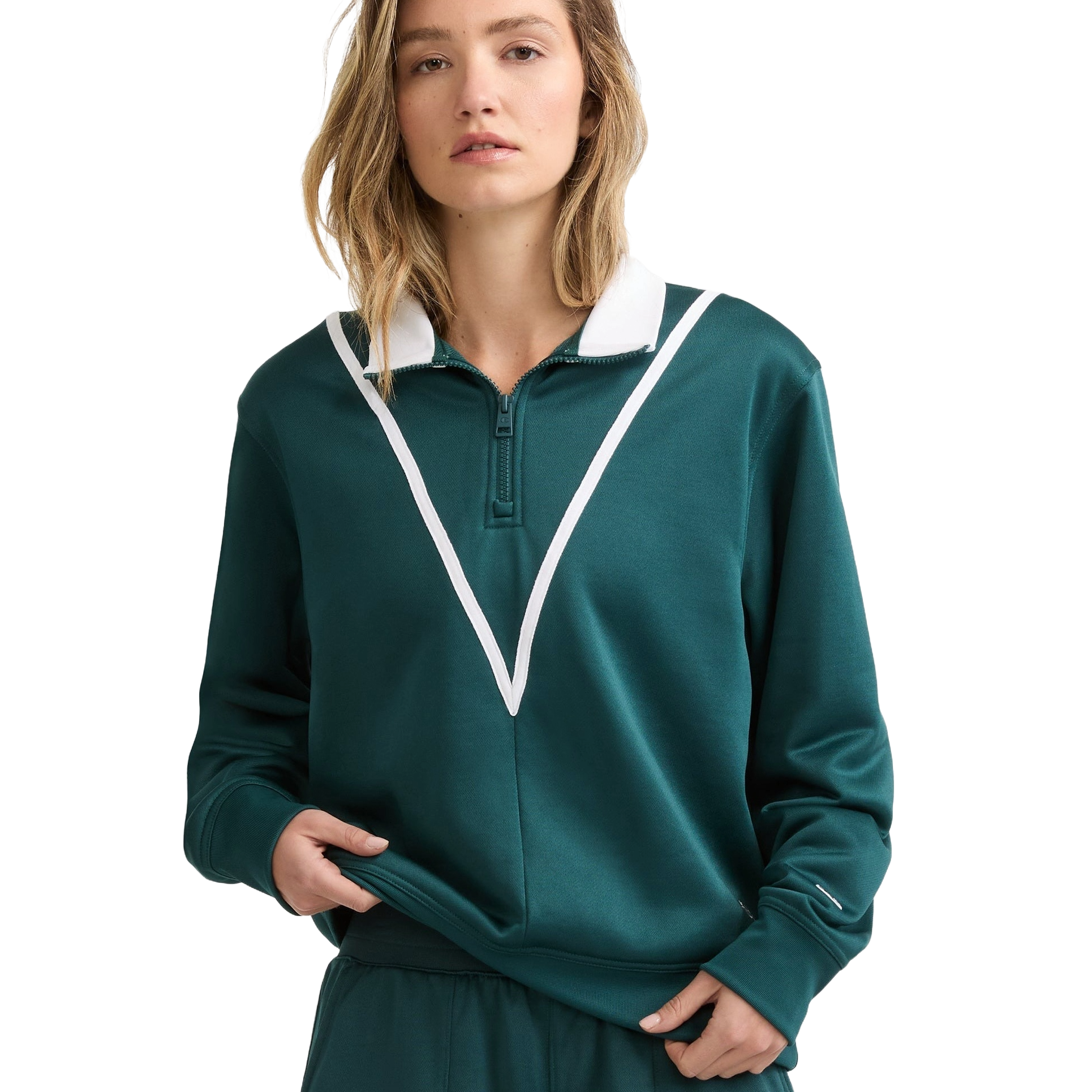 A woman wearing a green pullover with a white V-shaped stripe and a zipper at the collar. The outfit includes matching green pants.