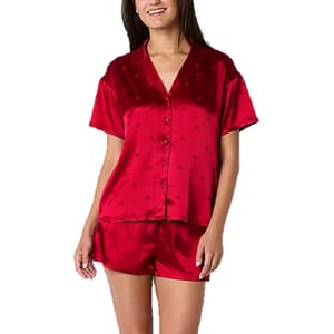 A red satin 2-piece pajama set consisting of a short-sleeved button-up top with a collar and matching shorts, both featuring a subtle heart pattern.