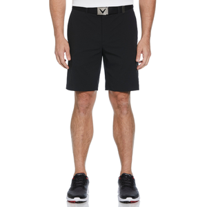 A person is wearing black shorts with a belt and black athletic shoes.