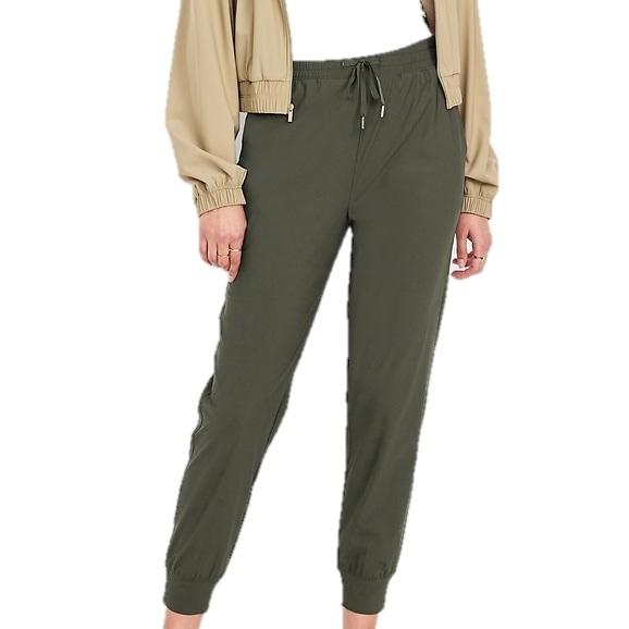 Olive green jogger pants with an elastic waistband and drawstring, paired with a beige jacket.