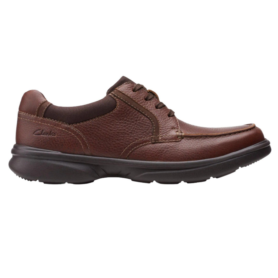 A brown leather lace-up shoe with a dark cushioned sole and stitch detailing, featuring a logo on the side.