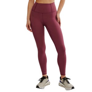A person is wearing high-waisted burgundy leggings paired with light-colored sneakers.