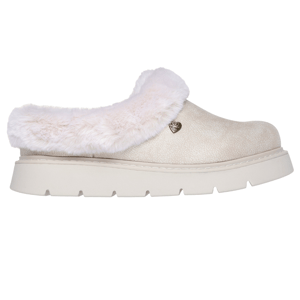 Skechers BOBS Keepsakes Slip-Ons are cozy slip-on shoes featuring a beige color with plush faux-fur lining, a cushioned footbed, and a heart-shaped metal accent. They offer comfort and a casual style with a flat platform sole.