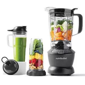 NutriBullet Blender Combo with a full-sized pitcher and two travel cups on a black base, filled with various fruits and vegetables.