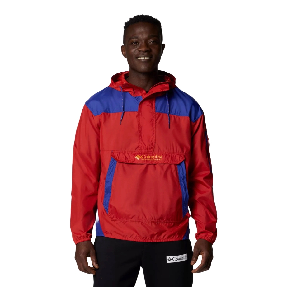 A person is wearing a Columbia anorak jacket in red and blue with a front pocket and black Columbia sweatpants.