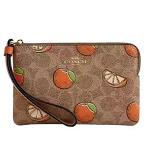 A wristlet with a brown pattern featuring orange fruit motifs and a strap, displaying a subtle brand logo.