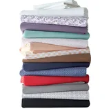 A stack of folded bed sheets in various colors and patterns, featuring shades of white, floral, purple, mint, peach, beige, brown, blue, red, gray, and black.