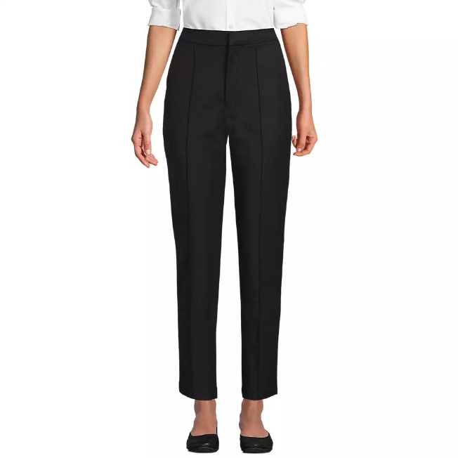 A pair of black, high-waisted straight-leg trousers paired with a white blouse and black shoes.