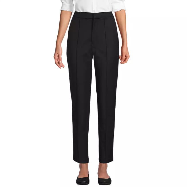 A pair of black, high-waisted straight-leg trousers paired with a white blouse and black shoes.