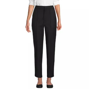 A pair of black, high-waisted straight-leg trousers paired with a white blouse and black shoes.