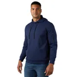 A man is wearing a navy blue hoodie with a front pocket, drawstrings, and a small zip pocket on the sleeve, paired with blue jeans.