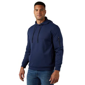 A man is wearing a navy blue hoodie with a front pocket, drawstrings, and a small zip pocket on the sleeve, paired with blue jeans.